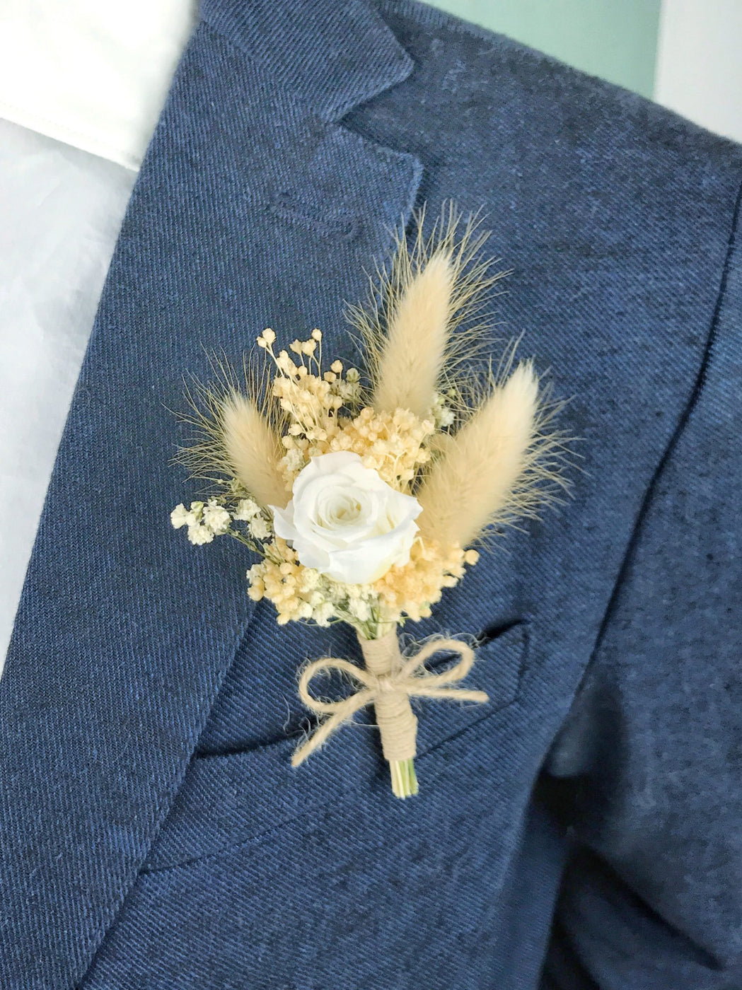Dried flower wedding boutonniere with ecru lagurus and small stabilized rose