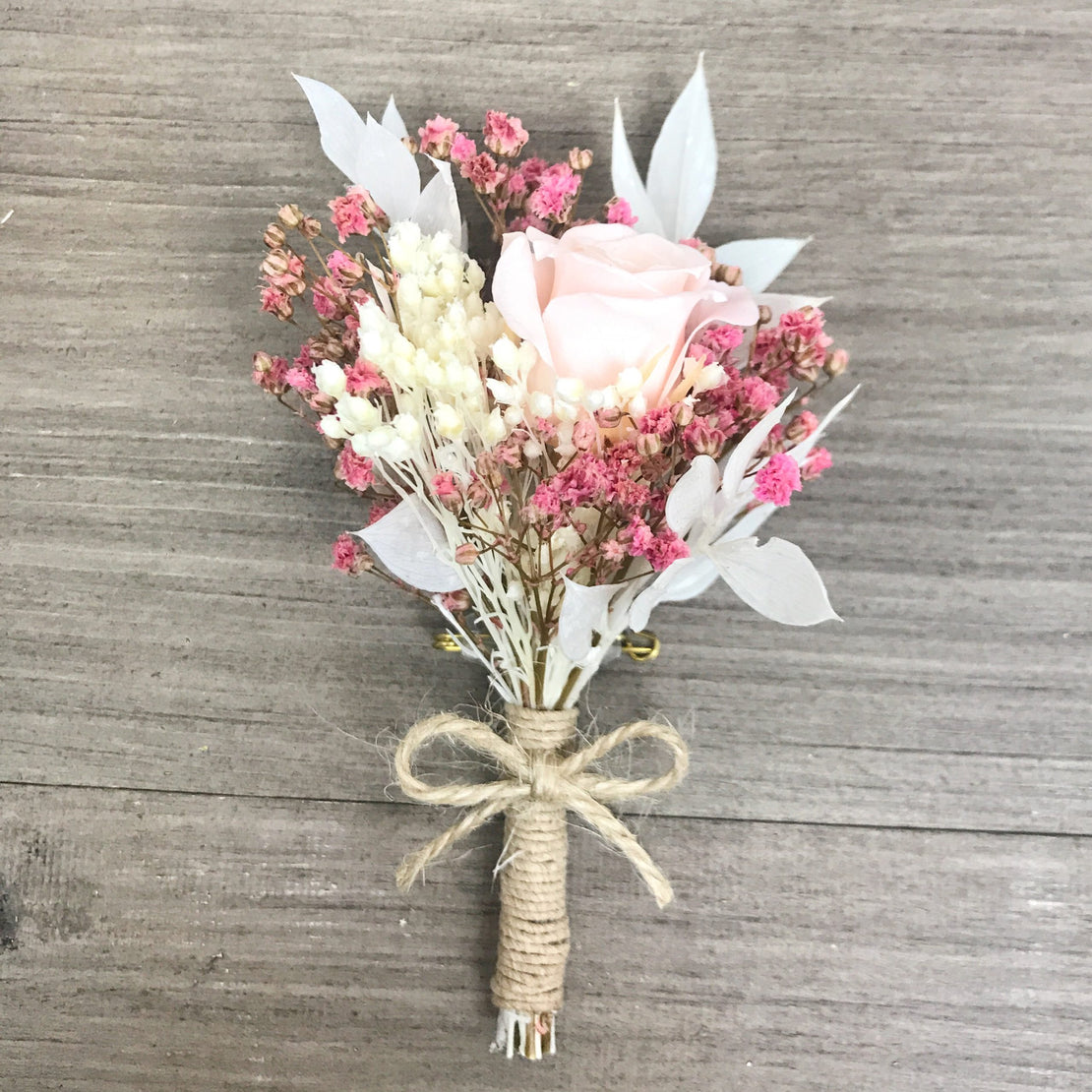 Dried flower wedding boutonniere with rose and stabilized pink gypsophila