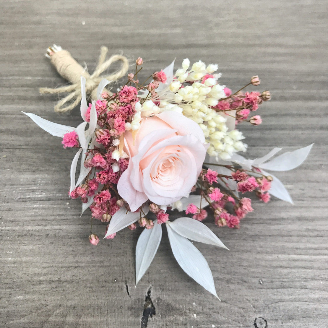 Dried flower wedding boutonniere with rose and stabilized pink gypsophila